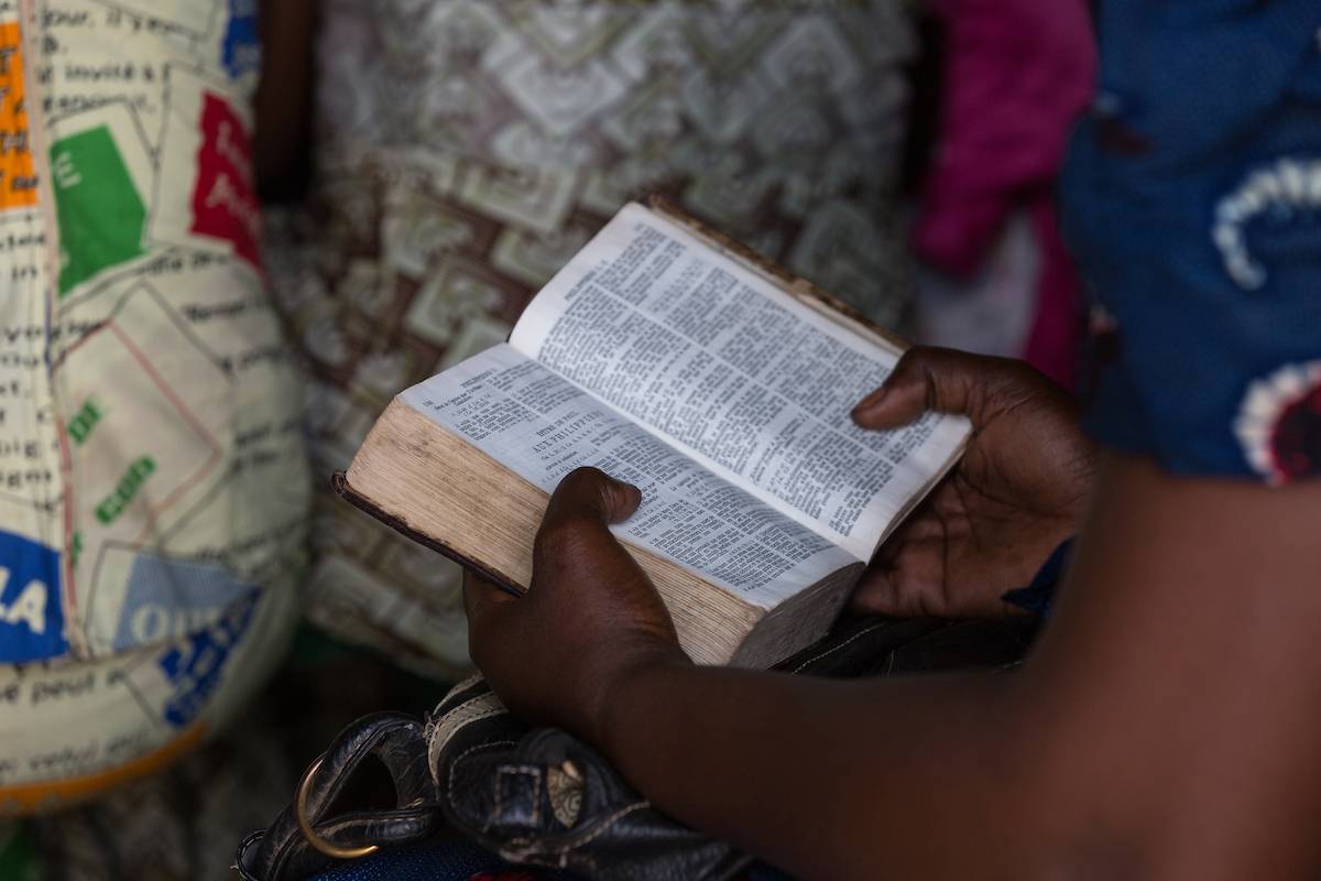 Hands holding open Bible.